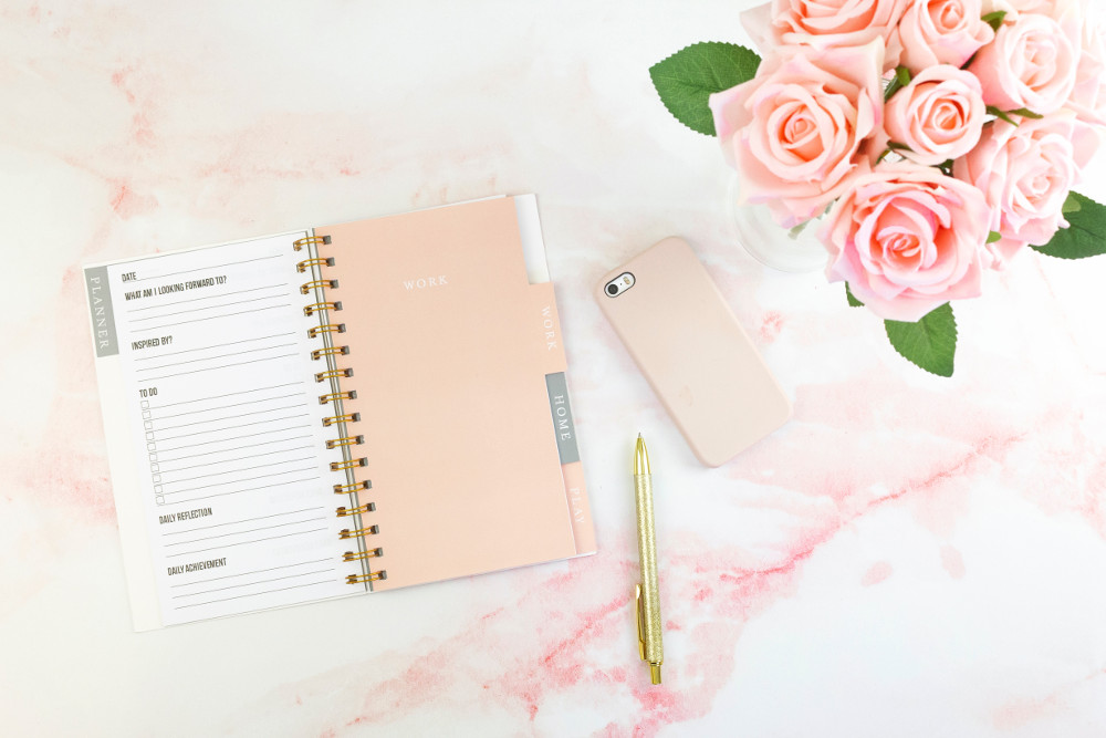 notebook, pen, smartphone, and flowers